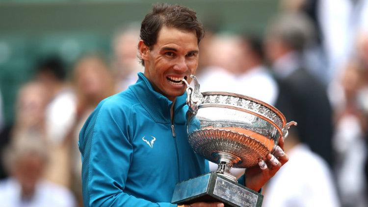Rafael Nadal memegang trofi Roland Garros. - INDOSPORT