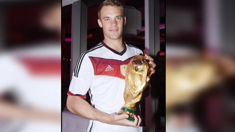 Manuel Neuer bersama trofi Piala Dunia 2014. Copyright: INDOSPORT
