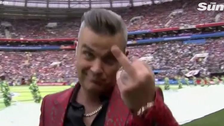 Robbie Williams kedapatan memberikan jari tengah di depan kamera. - INDOSPORT