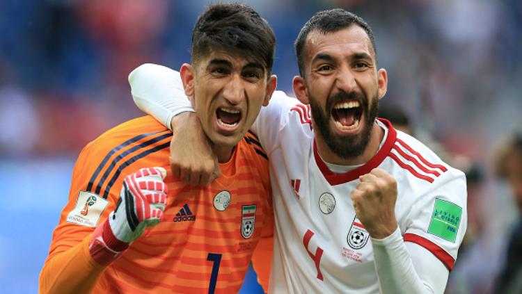Kiper Iran Alireza Beiranvand dan Rouzbeh Cheshmi selebrasi usai kalahkan Maroko di laga Grup B Piala Dunia 2018. Copyright: INDOSPORT