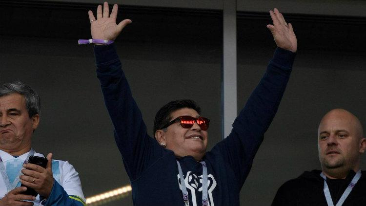 Diego Maradona menyapa penonton di tribune VIP laga Argentina vs Islandia di Piala Dunia 2018. Copyright: INDOSPORT.com