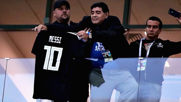 Diego Maradona memamerkan jersey Lionel Messi.
