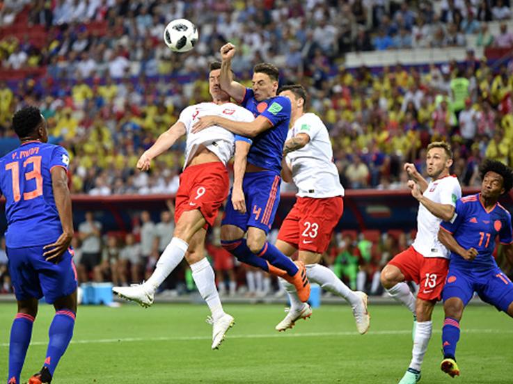 Lewandowski berduel dengan pemain bertahan Kolombia Copyright: INDOSPORT