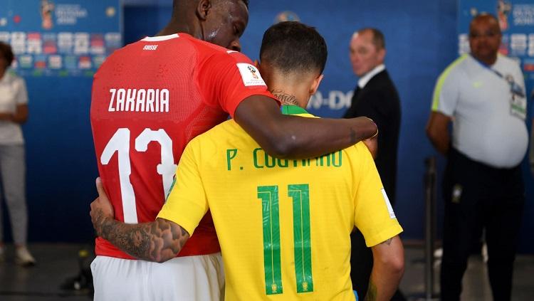 Bintang Brasil, Philippe Coutinho, berangkulan dengan pemain Swiss, Denis Zakaria.