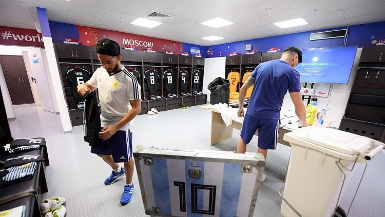 Sejumlah staff mempersiapkan perlengkapan bertanding Lionel Messi dkk di ruang ganti Timnas Argentina.