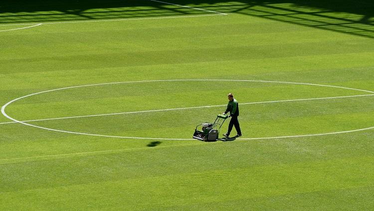 Petugas sedang merapikan rumput lapangan jelang laga Argentina vs Islandia.