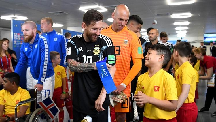 Megabintang Argentina, Lionel Messi, berbincang dengan maskot cilik di lorong stadion jelang laga perdana melawan Islandia.