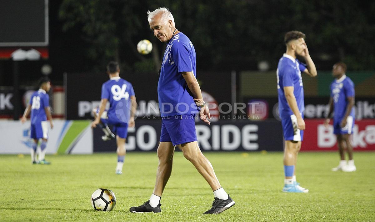 Pelatih Mario Gomez sedang memperhatikan kondisi rumput Stadion PTIK. Terlihat pelatih asal Argentina tersebut tidak puas dengan kualitas rumput tersebut. Copyright: Herry Ibrahim/Indosport.com