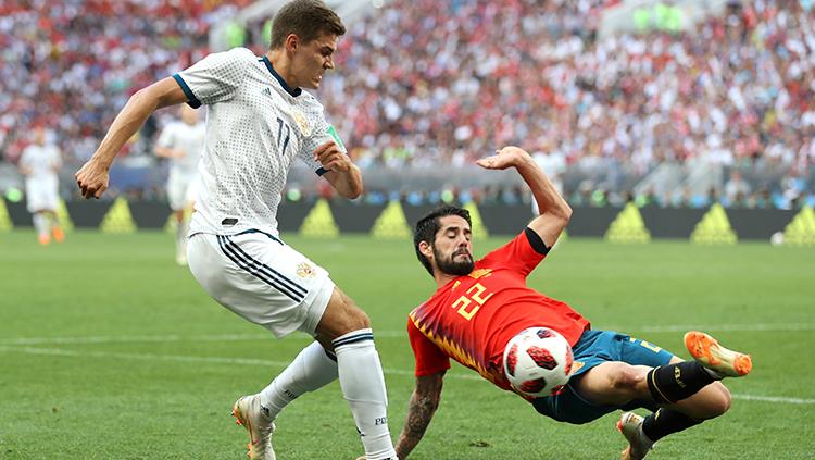 Isco mencoba memblok tendangan pemain Rusia.