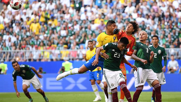 Guillermo Ochoa kiper Meksiko berhasil tepis bola dari serang pemain Brasil.