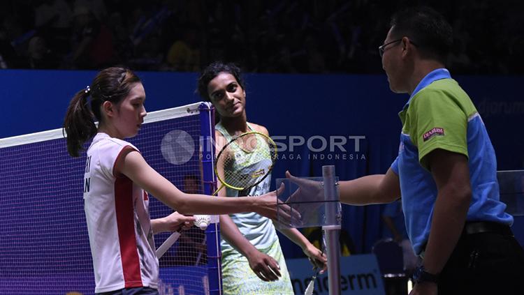 Tunggal putri India, P. V Sindhu (tengah) tersenyum memandang tunggal putri Jepang, Aya Ohori usai pertandingan.