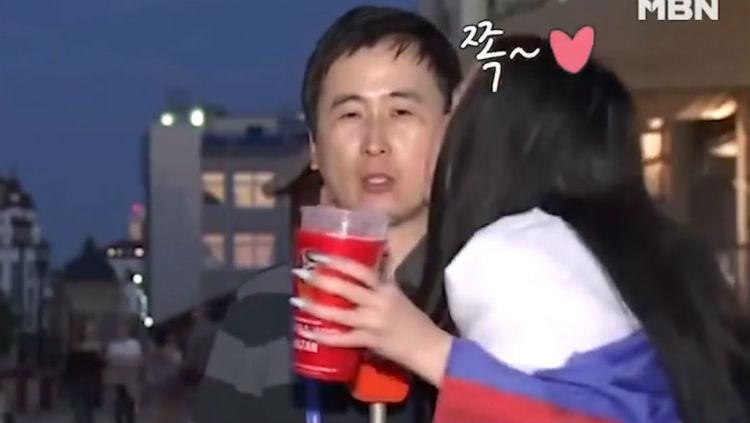 Reporter asal Korea Selatan, Jeon Gwang-ryeol, mendapat ciuman dari fans Rusia. - INDOSPORT