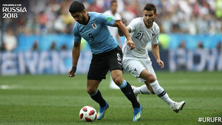 Suarez (kiri) sedang mengontrol bola. Copyright: twitter@fifaworldcup