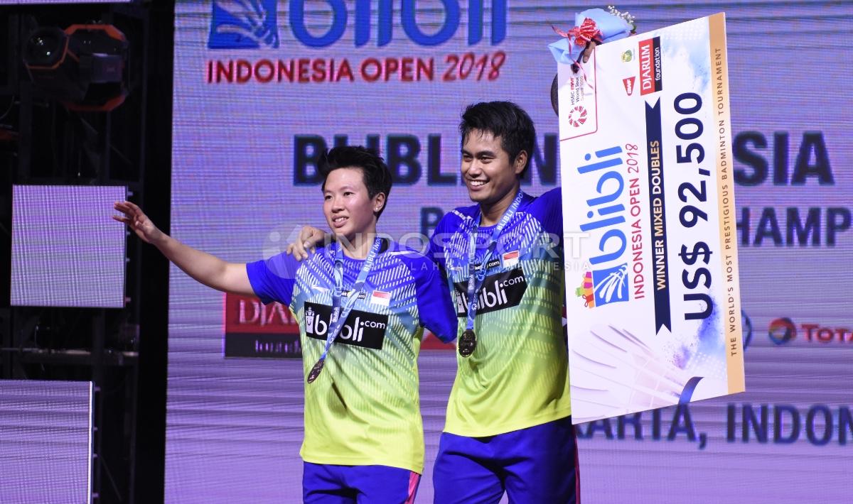 Ganda Campuran Indonesia Tontowi Ahmad dan Liliyana Natsir membawa poster hadiah sebagai juara Indonesia Open 2018.