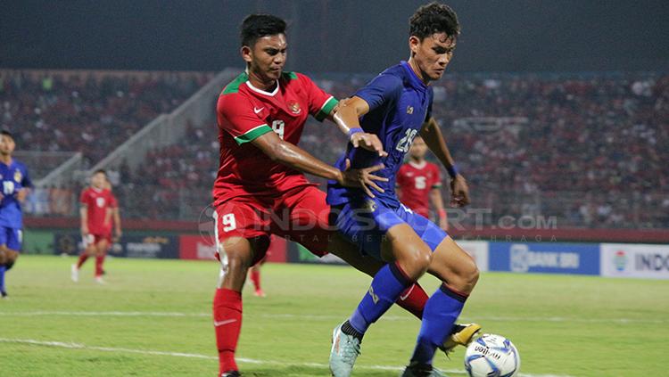 Muhammad Rafli Mursalim saat mengawal ketat pemain Thailand di Piala AFF U-19. Kini ia resmi berlabuh ke klub Liga Kamboja, Nagaworld FC.