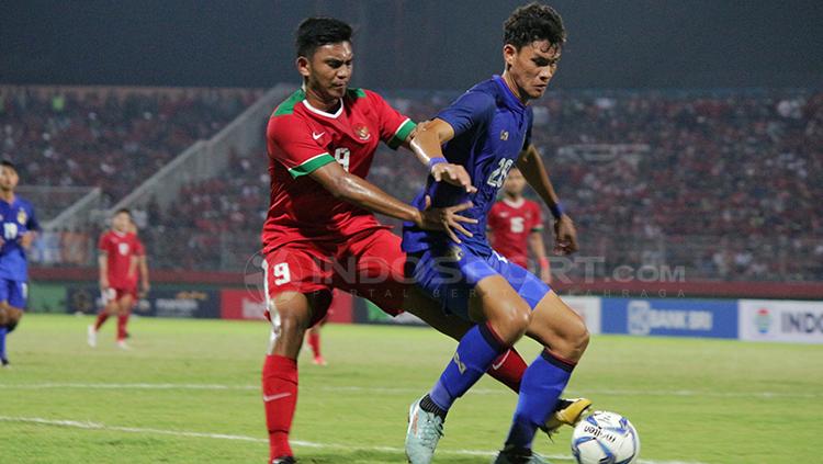 Muhammad Rafli Mursalim saat mengawal ketat pemain Thailand di Piala AFF U-19. Kini ia resmi berlabuh ke klub Liga Kamboja, Nagaworld FC. - INDOSPORT