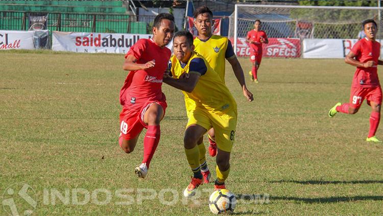 Aksi saling tekel terhampar dalam laga Madura FC vs Persegres GU. Copyright: INDOSPORT/Ian Setiawan