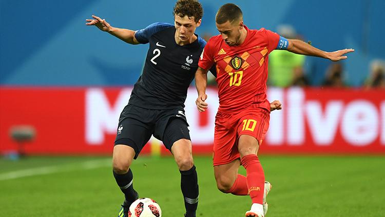 Eden Hazard mencoba merebut bola di kaki Benjamin Pavard. Copyright: INDOSPORT