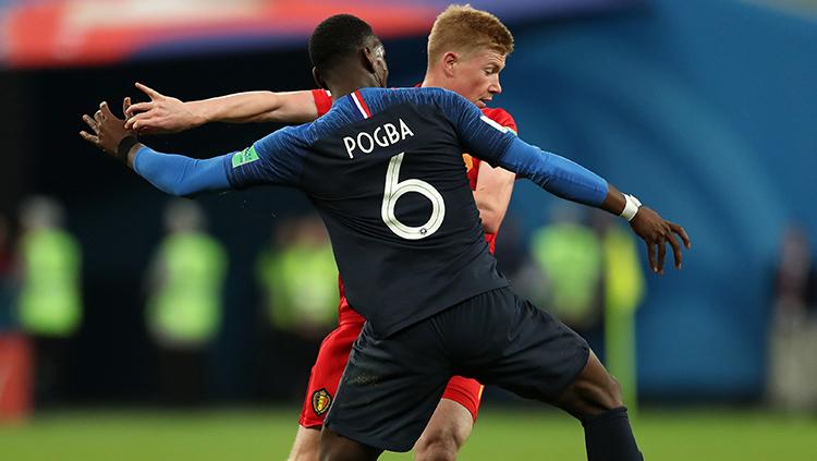 Paul Pogba mencoba merebut penguasaan bola dari De Bruyne. Copyright: INDOSPORT