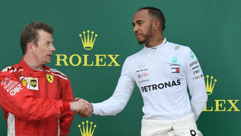 Kimi Raikkonen dan Lewis Hamilton saling berjabat tangan di atas podium.