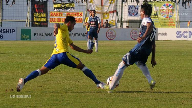 Samsul Arif saat merebut bola pemain lawan di pertandingan Barito Putera vs Arema FC Liga 1 2018.