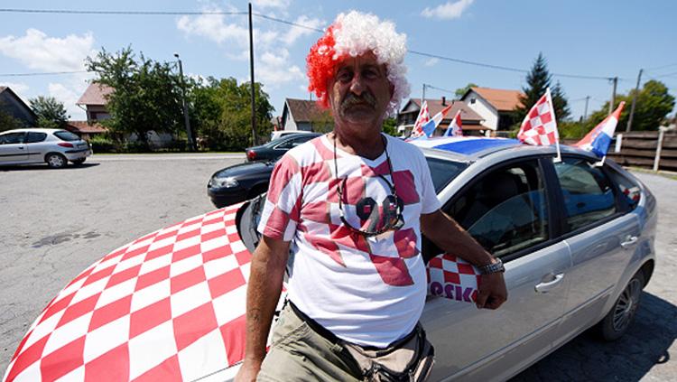 Totalitas tanpa batas disuguhkan oleh salah satu fans Kroasia ini. Bukan hanya rambutnya saja dicat, bahkan kap mobilnya pun dicat berbentuk bendera Kroasia.