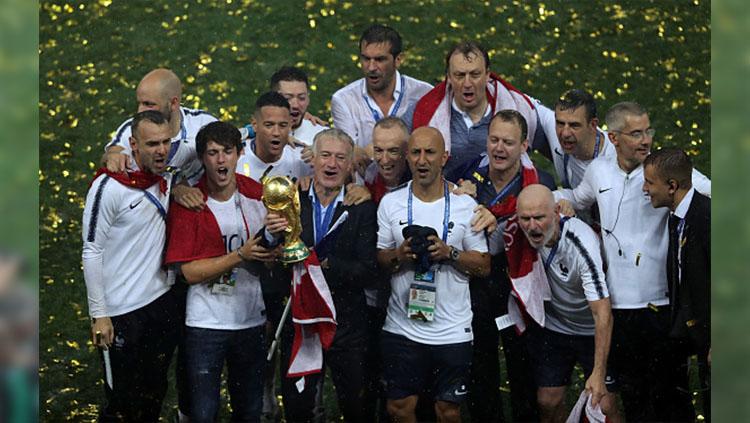 Ekspresi kegembiraan Didier Deschamps dan staf pelatih Timnas Prancis sambil memegang trofi Piala Dunia.