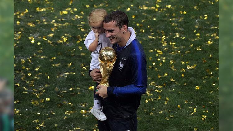 Antoine Griezmann bersama putrinya Mia merayakan keberhasilan Prancis menjadi jaura dunia.