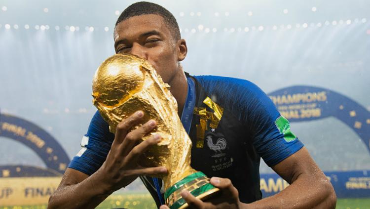 Kylian Mbappe dengan trofi Piala Dunia 2018. - INDOSPORT