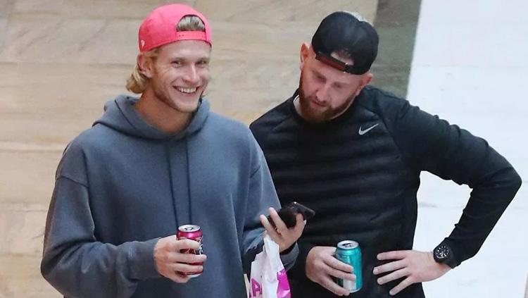 Loris Karius menunjukan sesuatu dari hp untuk temanya. Copyright: thesun.co.uk