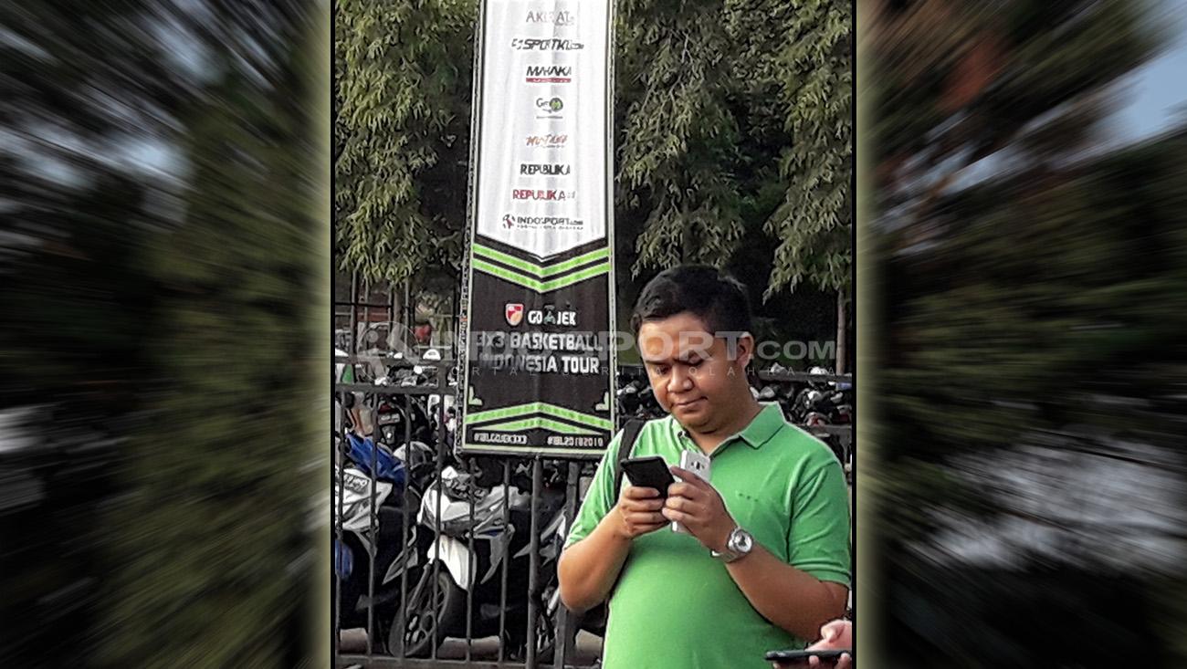 Salah satu penonton dengan latar belakang banner IBL Gojek 3x3 Malang.