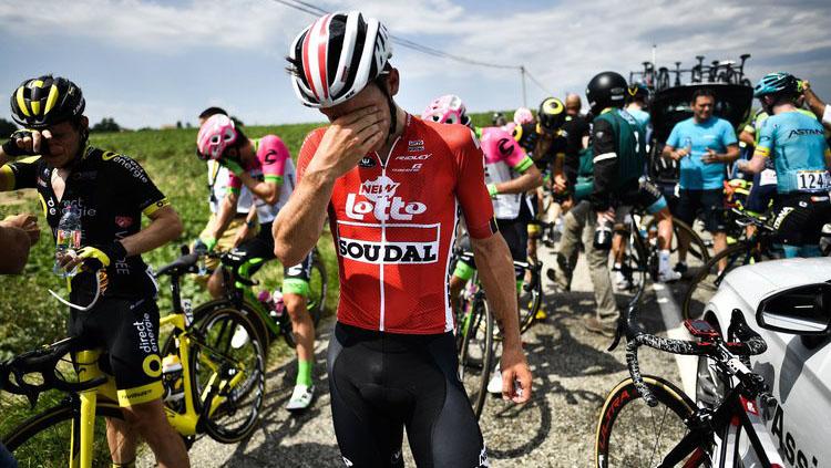 Para pembalap sepeda di Tour de France 2018 tampak mengusap mata mereka yang terkena gas air mata dari polisi setempat. - INDOSPORT