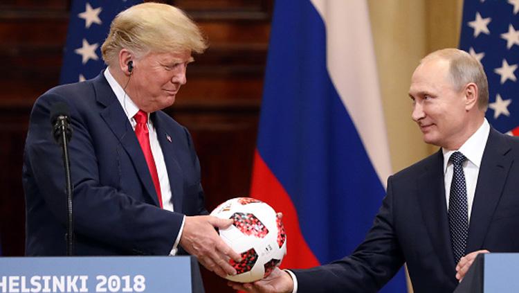 Usai gelar Piala Dunia 2018, Presiden Rusia, Vladimir Putin (kanan) berikan sebuah bola ke Presiden Amerika Serikat, Donald Trump.