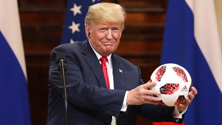 Presiden Amerika Serikat, Donald Trump memamerkan bola Piala Dunia 2018 yang diberikan Presiden Rusia, Vladimir Putin.