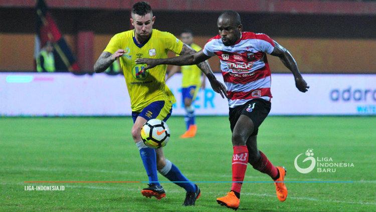 Greg Nwokolo berduel dengan pemain lawan di Liga 1 2018.