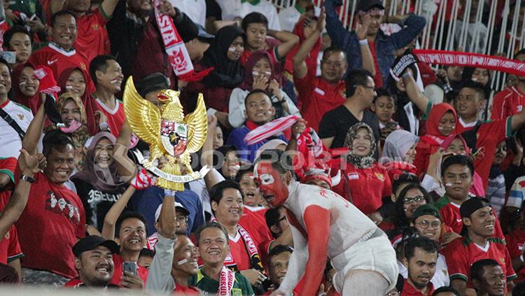 Suporter Indonesia, Andi Kiswantoro, membawa patung Garuda Pancasila.