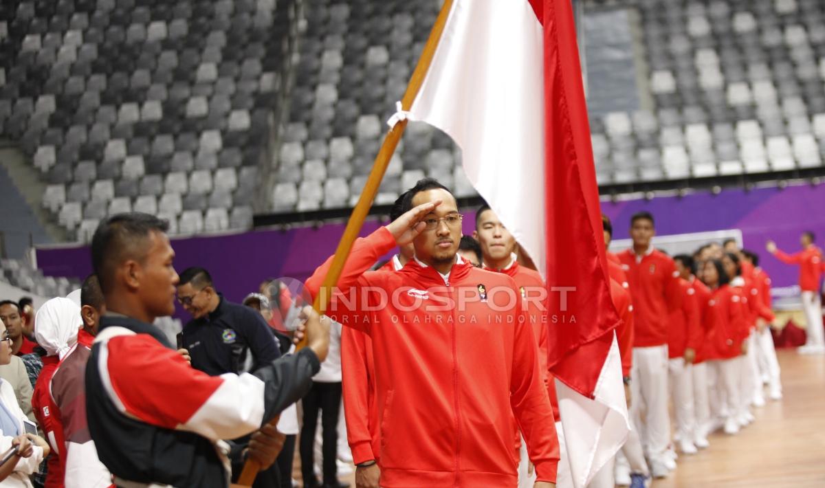 Salah satu atlet kontingan Indonesia untuk Asian Games 2018 memberi hormat ke Bendera Merah Putih.