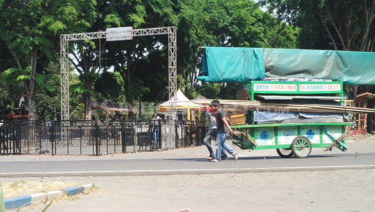 Pedagang kaki lima melintasi lokasi nobar. Copyright: Fitra Herdian/Indosport