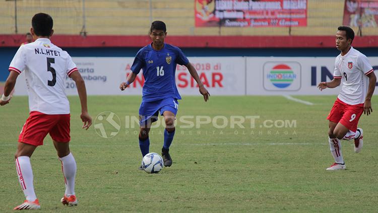 Pemain Myanmar berusaha menutup pergerakan pemain Thailand. Copyright: Fitra Herdian/Indosport