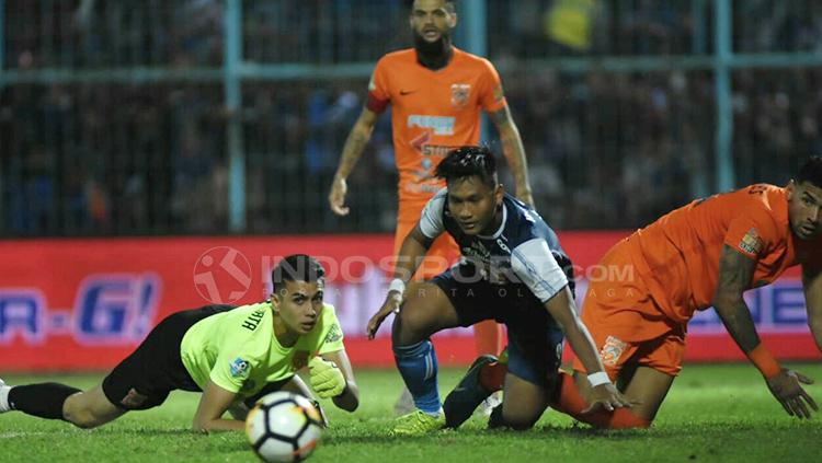 Ahmad Nur Hardianto memandang bola setelah upayanya mencetak gol digagalkan Nadeo Argawinata.