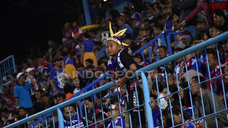 Aremania kecil tetap semangat mendukung Arema.