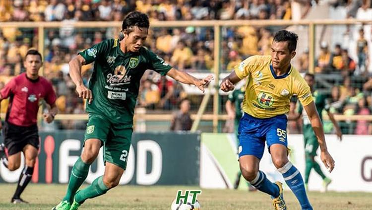 Dandi Maulana (kanan) berusaha menghalau pemain Persebaya.