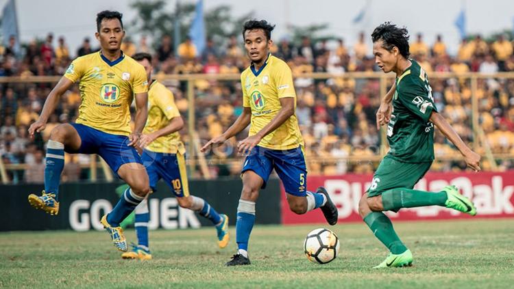 Rishadi Fauzi melepaskan tendangan keras.