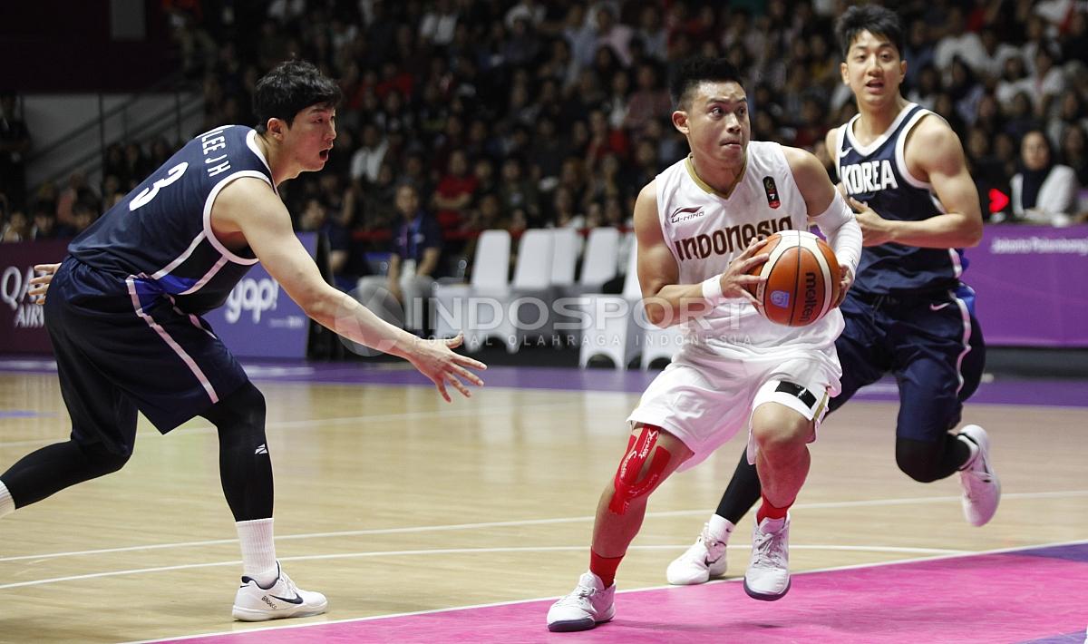 Aksi pebasket Indonesia, Andakara Prastawa (tengah) melewati hadangan dua pemain Korea. - INDOSPORT