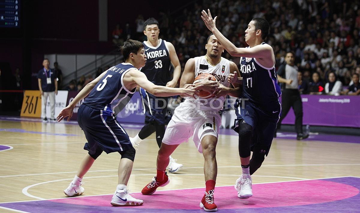 Pergerakan pebasket Indonesia, Arki Dikania Wisnu (tengah) dihadang tiga pemain Korea.