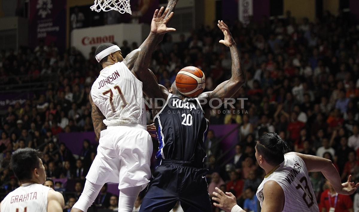 Aksi lay up pebasket Korea, Ricardo Preston (kanan) berhasil digagalkan oleh pemain Indonesia, Jamar Andre Johnson.