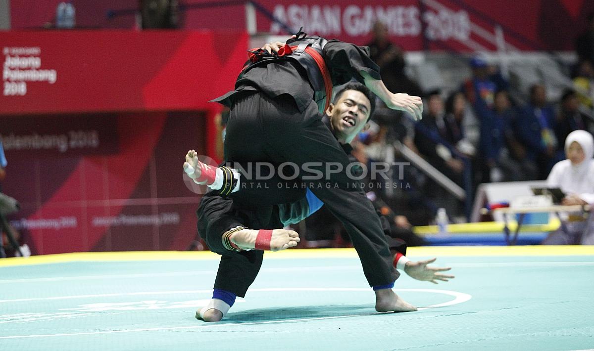 Pesilat Indonesia, Amri Rusdana (sabuk biru) melawan Pesilat Uzbekistan, Nurulla Saidov pada babak 16 besar Kelas F Putra 70kg-75kg di Padepokan Pencak Silat TMII, Rabu (23/08/18). Amri menang 5-0 atas lawannya.