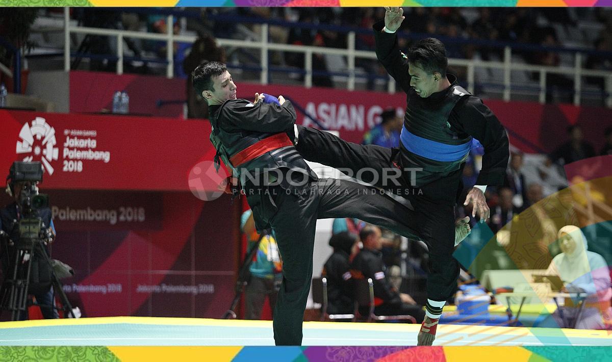 Pesilat Indonesia, Amri Rusdana (sabuk biru) melawan Pesilat Uzbekistan, Nurulla Saidov pada babak 16 besar Kelas F Putra 70kg-75kg di Padepokan Pencak Silat TMII, Rabu (23/08/18). Amri menang 5-0 atas lawannya.