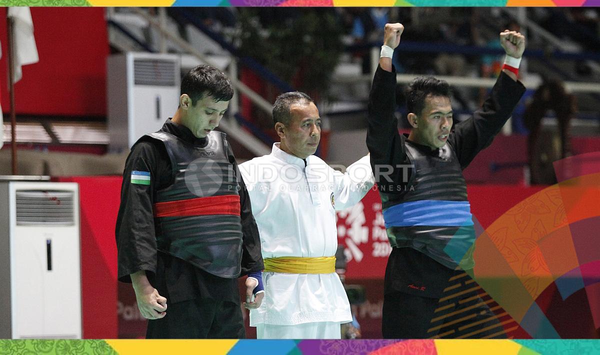 Pesilat Indonesia, Amri Rusdana (sabuk biru) melawan Pesilat Uzbekistan, Nurulla Saidov pada babak 16 besar Kelas F Putra 70kg-75kg di Padepokan Pencak Silat TMII, Rabu (23/08/18). Amri menang 5-0 atas lawannya.