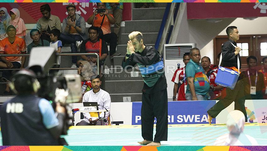 Atlet silat Indonesia, Hanifan Yudani Kusumah (sabuk biru) melawan pesilat Laos, Phoumiphon Vongphakdy (sabuk merah) pada babak perempat final kelas C Putra: 55-60kg di Padepokan Silat TMII, Sabtu (25/08/18).